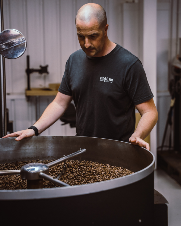 man next to coffee roaster