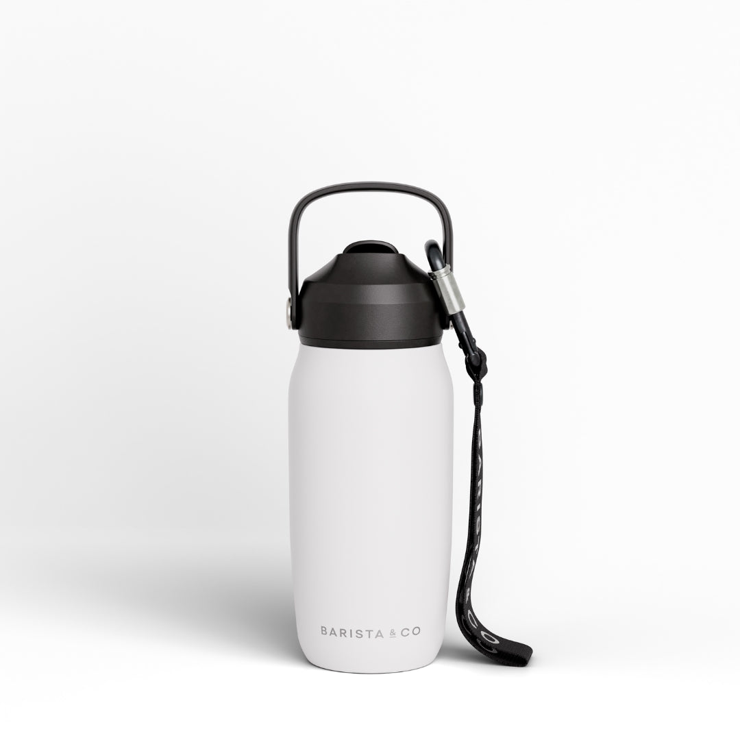 A matte white insulated water bottle with a black lid, carrying loop, and black wrist strap, shown on a clean white background. The brand name 'BARISTA & CO' is printed near the bottom.