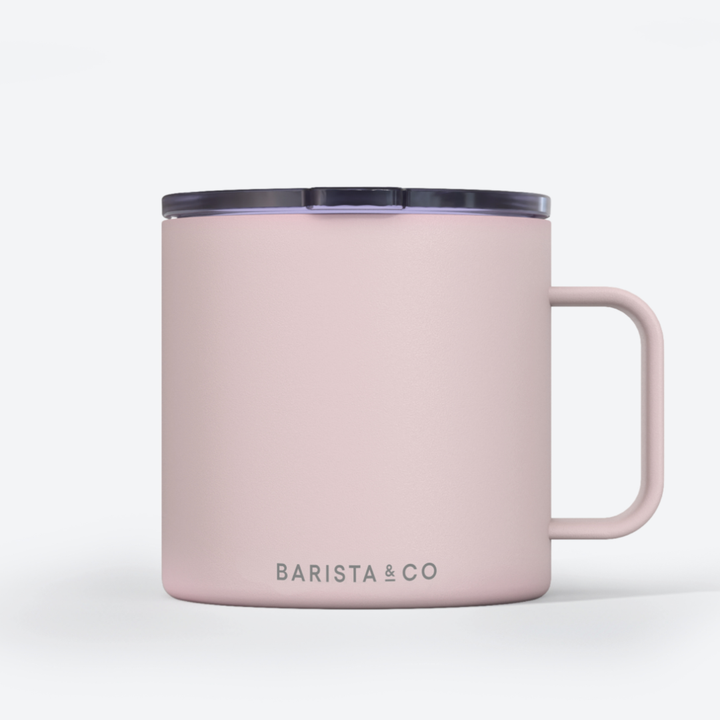 A light pink insulated mug with a matching pink handle and a dark gray lid, featuring the 'BARISTA & CO' logo printed in gray near the bottom, set against a clean white background.
