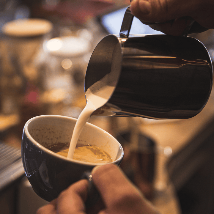 pouring latte with black pearl dial in milk jug