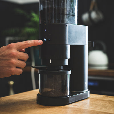 Fresh ground coffee at home with Barista & Co electric grinder on wooden table